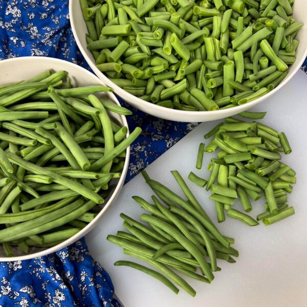green beans trimmed, some cut,  some long on cutting board and in bowls