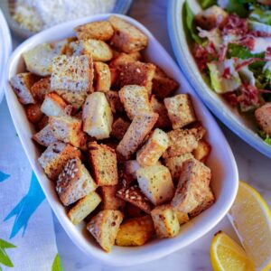 homemade croutons in dish beside salad