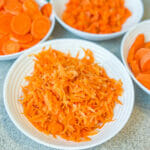 bowl of blanched shredded carrots other carrot bowls behind
