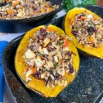 two half stuffed acorn squash on baking pan