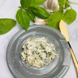 basil herb butter on plate with gold butter knife