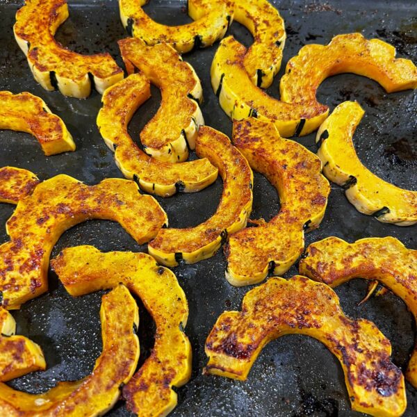 roasted delicata slices on baking sheet