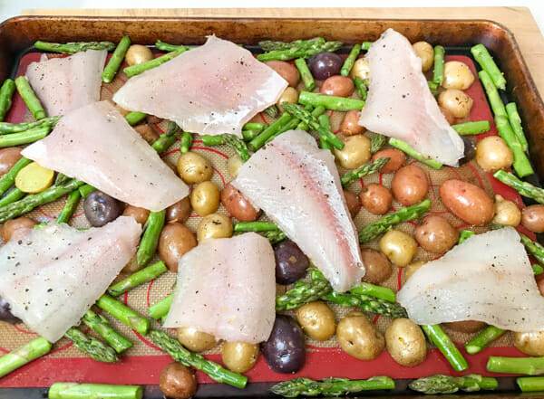 the fish on top of potatoes and asparagus