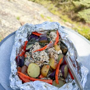 chicken foil pack in foil on plate outside