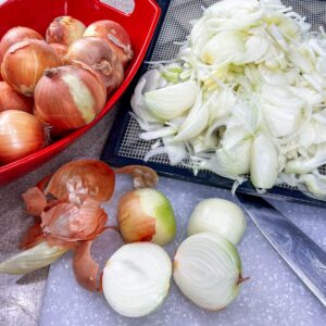 whole and chopped onions on counter with knife