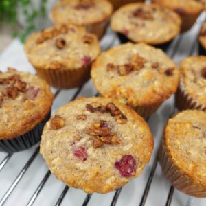 cranberry oat muffins on cooling rack showing nuts on top