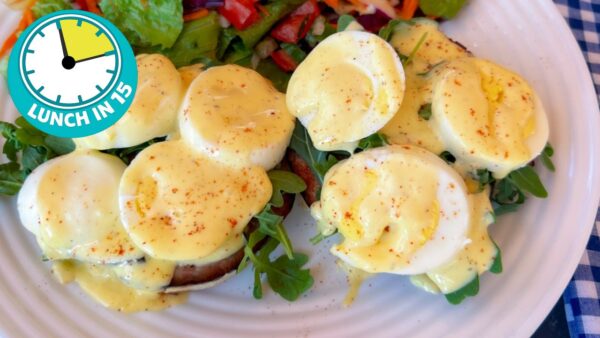 plate of open faced hard cooked eggs benedict muffins showing sliced hard cooked eggs with hollandaise sauce