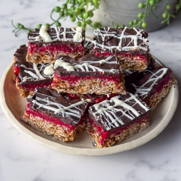 no bake chocolate raspberry oat bars stacked on serving plate
